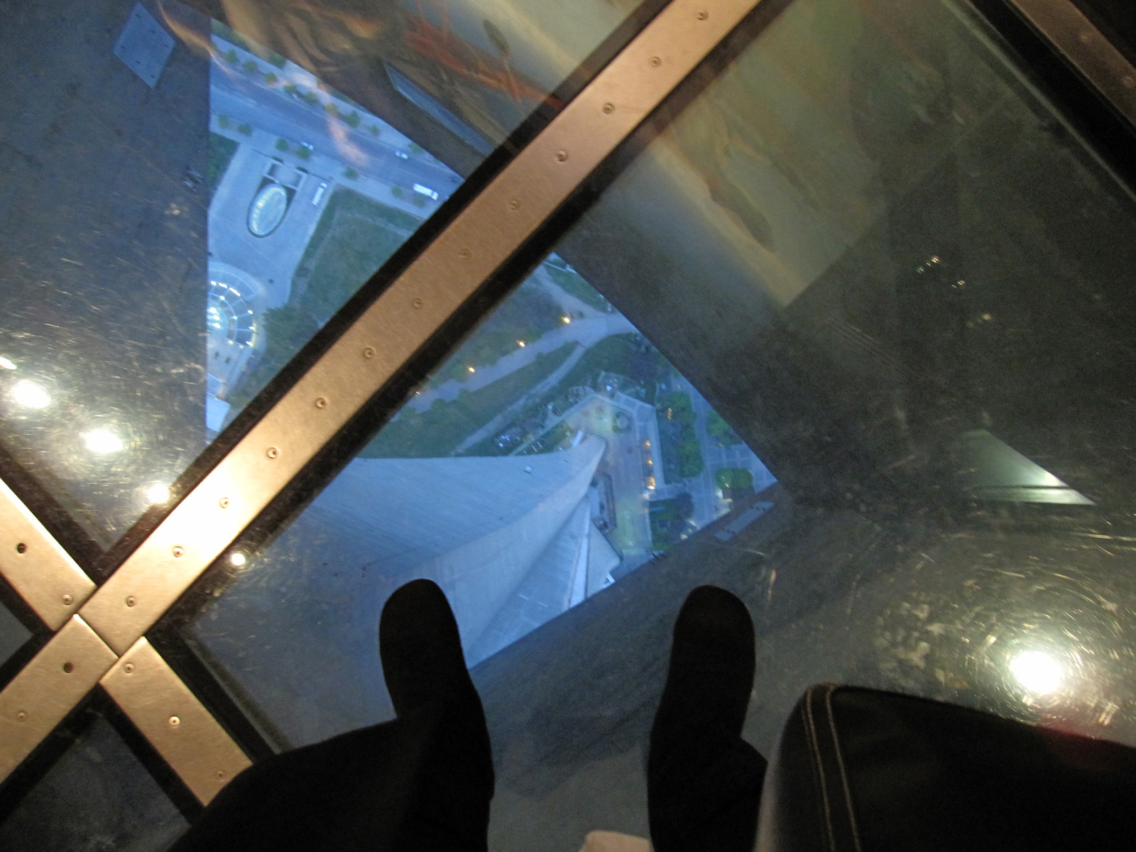 Looking straight down through a glass floor high above a city street